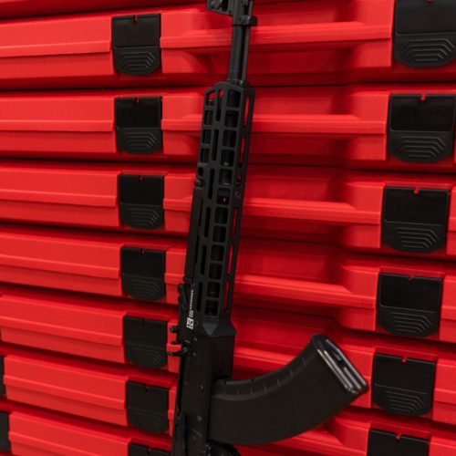 RS Regulate black GKR-10MS M-Lok Rail for KR-103 Rifle installed on gun in front of red rifle cases